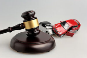 toy cars beside hammer and gavel: a car accident law concept