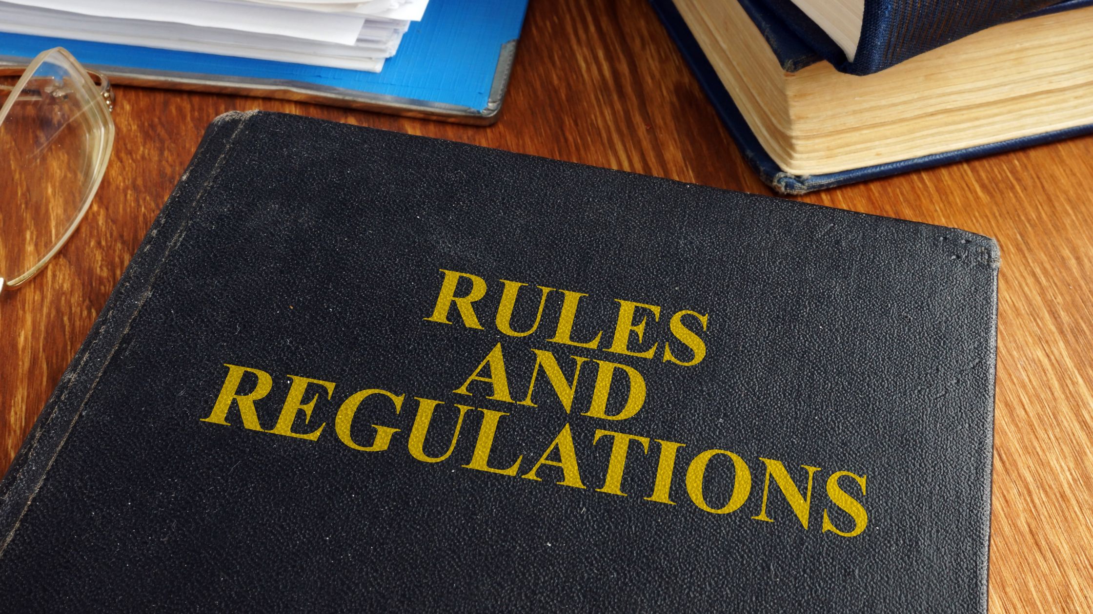 A book titled 'RULES AND REGULATIONS' on a desk, symbolizing the federal regulations for truck drivers that could influence a legal case.